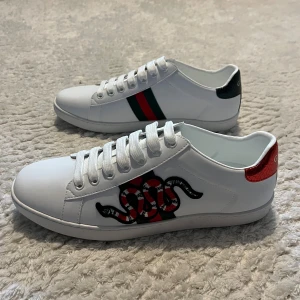 Gucci Ace sneakers med orm och ränder - Säljer ett par Gucci Ace skor med orm på sidorna, riktigt snygga och knappt använda. Klockrena och passar perfekt om du vill ha en klassiskt stil. Säljer pga skorna var för stora på mig. Priset är inte hugget i sten vid en snabb affär, men säljer för bra pris jämfört med nypris i affären. 