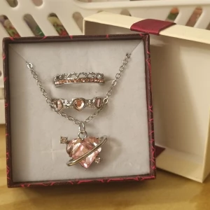 Smyckeset  - Ett justerbart halsband och två ringar i storlek 7 (55). Asken ingår. Material : koppar 