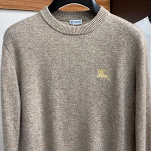 Beige stickad tröja från Burberry - Säljer en beige stickad tröja från Burberry med klassisk rund halsringning och diskret broderad logga i gult på bröstet. Bara kvitto som saknas. Allt annat finns med ! 