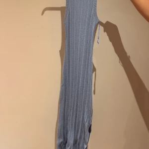 Blå ribbad klänning från & Other Stories - Säljer en blå ribbad klänning från & Other Stories. Klänningen är ärmlös, har rund hals och en slits på sidan. Den är stickad i ett mjukt material och har en figurnära passform som framhäver siluetten. Klänningen som säljs är den blå, men det är samma passform som den vita. 