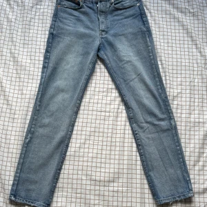 jeans straight fit - Klassiska Levi's 501 jeans i ljusblå tvätt med raka ben och knappgylf. Jeansen har fem fickor, tydliga sömmar och den ikoniska röda Levi's-taggen bak. Perfekta för en avslappnad och tidlös look.