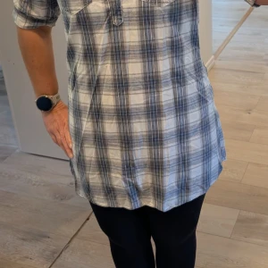 Blårutig henley-skjorta med knappar - Snygg blårutig henley-skjorta från Wear it med två bröstfickor och knappar framtill. Välj mellan att ha ärmarna nere eller  upprullade och fastsatta med knapp. Perfekt för en avslappnad och cool look.