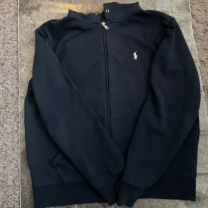 Ralph lauren zip hoodie  - En Ralph lauren zip hoodie storken är M i barn så 172 bra skick ställ frågor pris kan diskuteras färgen är mörkblå ny pris kan vara upp mot 1500 men säljer det billigare även om den är oanvänd 