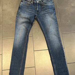 Blå jeans från Jack & Jones - Snygga blå jeans från Jack & Jones. Jeansen har en lätt tvättad look med subtila slitningar och är tillverkade i mjukt denimtyg som sitter skönt hela dagen. W30 L30. 