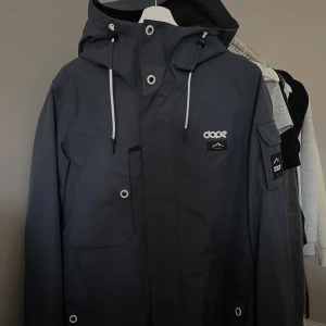 Dope - Snygg mörkblå vindjacka från Dope med huva och vita dragsnören. Jackan är endast provad och använd 1 gång. 