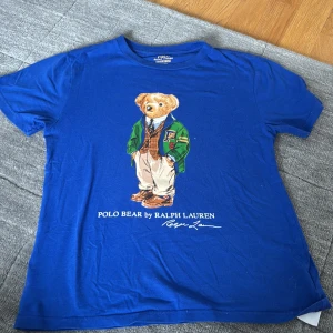 Blå Ralph lauren tshirt - Säljer en blå t-shirt från Polo Ralph Lauren! Skick 9/10✅Nypris 799 mitt pris 199kr! Hör av dig vid minsta intresse! Passar runt 150-165 cm lång