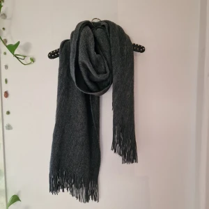 Mjuk grå hanslduk - Grå SUPERmjuk halsduk, som är mycket väl omhändertagen. Pga flytt och att den är inte min stil längre, så får den hitta en annan hals att värma. 2 meter (dubbelvikt på bild, så 1m+1m)  lång och 62 cm bred (blir riktigt go och tjock runt halsen, så den värmer ordentligt!) 