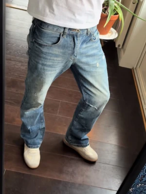  ljusblå jeans straight/bootcut - W29/L32 Säljer ett par klassiska jeans i ljusblå tvätt med slitningar och distressed detaljer. Modellen har rak/bootcut passform och normal midja. Från peices of life studio, Jeansen har fem fickor samt knappgylf. Perfekta för en avslappnad och cool stil. Säljer pga inte passar mig.