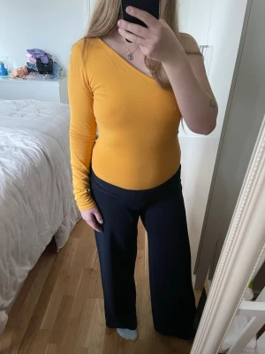Gul oneshoulder topp från NA-KD - Säljer en snygg gul/orange oneshoulder body från NAKD. Använd ett par gånger endast, i bra skick!