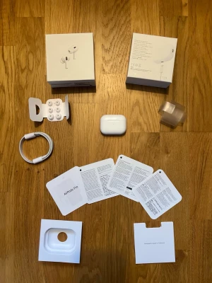 Apple AirPods Pro 2 - Säljer ett par Apple AirPods Pro med vitt laddningsetui, originalkartong, extra silikonpluggar, USB-C laddkabel och manualer. Hörlurarna är vita, har en stilren och kompakt design i blank plast och levererar grymt ljud med brusreducering. Perfekt för musik, poddar och samtal. Skicka gärna en meddelande för mer info.