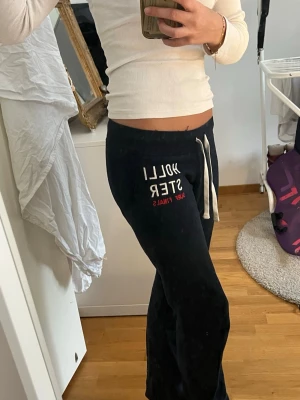 Coola low waist Hollister mjukisbyxor  - Svarta mjukisbyxor från Hollister med vit dragsko i midjan och tryckt logga i vitt och rött på vänster lår. Super coola och mysiga.