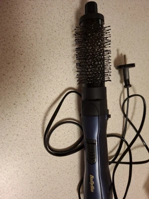 BaByliss varmluftsborste blå - Säljer en blå varmluftsborste från BaByliss med rund borste och svarta borststrån. Handtaget är ergonomiskt format och har en sladd med vanlig stickkontakt. Perfekt för styling och volym till håret.
