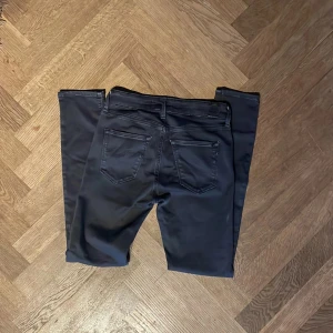 Replay Hyperflex svarta Jeans - Svarta Replay Hyperflex jeans i modellen New Luz med skinny fit och klassisk femficksdesign. Jeansen har dragkedja och knapp framtill, samt stretchigt material som ger grym komfort och rörelsefrihet. Perfekta för dig som gillar en tajt och stilren look.