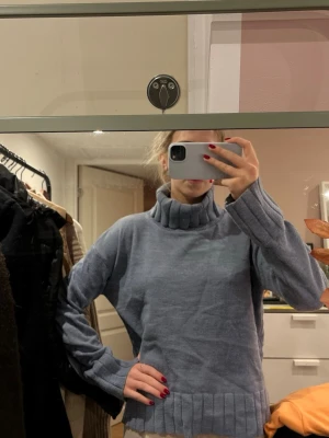 Blå stickad polotröja  - Mysig blå stickad polotröja med breda ribbade muddar vid ärmslut och nederkant. 