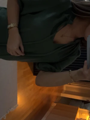 mörkgrön blus  - Snygg grön omlottopp från Vero Moda med puffärmar och knytband framtill. Toppen har v-ringning och är tillverkad i ett mjukt material som känns skönt mot huden. Perfekt att styla med jeans eller kostymbyxor för en elegant look.