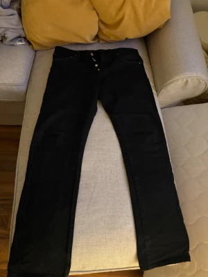Svarta Levi's 501 jeans straight fit - Klassiska vintage svarta Levi's 501 jeans med rak passform och knappgylf. Jeansen är tillverkade i slitstark bomullsdenim. W 32 L 32. Skicka bud:)