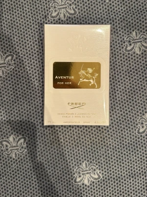 Creed Aventus For Her parfym 75 ml - Lyxig parfym från Creed, Aventus For Her, i elegant vit och guld förpackning. Flaskan rymmer 75 ml och har en exklusiv känsla med guldfärgad etikett och klassisk design. Perfekt för dig som vill ha en unik och sofistikerad doft.                               Orginal priset ligger på cirka 4000 kr. Kommer i Orginal förpackning, helt oöppnad.