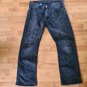 Levi's 559 svarta jeans 33/32 - Säljer ett par svarta Levi's 559 jeans med raka ben. Jeansen har en mörk tvätt med lätt slitning och är tillverkade i denim