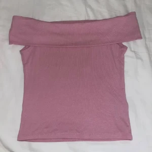 Rosa offshoulder topp från Stradivarius - Säljer en ljusrosa offshoulder topp från Stradivarius i storlek S. Materialet är mjukt och stretchigt, troligen bomull med inslag av syntet. Väldigt fin topp som aldrig är använd. Superduper fin!