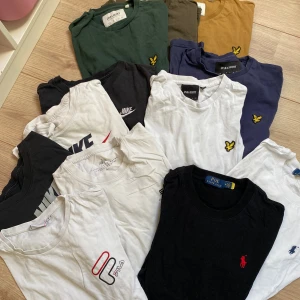 T-shirtpaket Nike, Lyle & Scott, Polo, Fila - Flera snygga t-shirts från Nike, Lyle & Scott, Polo Ralph Lauren och Fila. Färgerna är svart, vit, grön, blå och beige. Klassiska loggor på bröstet, rund hals och kort ärm. Perfekt för dig som gillar streetwear och sportiga vibes.