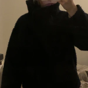 Marinblå/Svart fluffig kappa från GinaTricot - Mysig svart/marinblå kappa med hög krage och lång ärm. Kappan är lite fluffig och har en loose passform, perfekt för kyliga dagar. Enkel att matcha med jeans eller leggings för en chill look. Pris går att diskutera!