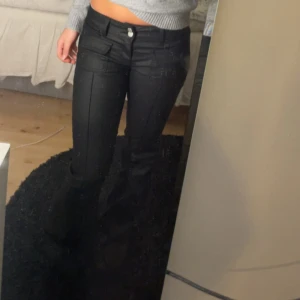 Svarta bootcut skinbyxor från Nelly  - Snygga svarta skinbyxor med bootcut och markerad söm längs benen. Byxorna har två framfickor med lock, fickor bak på rumpan och dubbla knappar i midjan. De är den gamla modellen från Nelly i storlek 36/S skulle också säga att den passar xs också 