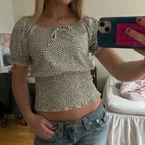 Prickig blus med puffärm och knyt - Säljer denna superfina toppen från zink! Toppen är i storlek S, men skulle säga att den passar nån med mindre/ större storlek då den är smockad runt midjan. Toppen är ändast använd 5 ggr!
