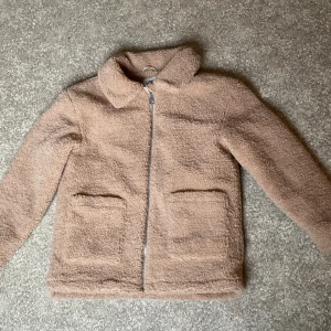 Beige teddyjacka från KappAhl - Mysig teddyjacka från KappAhl i beige färg. Har endast använts en säsong och har inga defekter. Kom gärna med prisförslag!