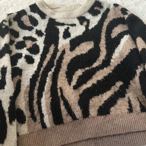 Leopardmönstrad stickad tröja Vero Moda - Säljer en stickad tröja från Vero Moda i storlek M men sitter som S/M med leopard- och zebramönster i svart, beige och brunt. Tröjan har rund halsringning och ribbade muddar. Köpte tröjan för 400kr 🩷