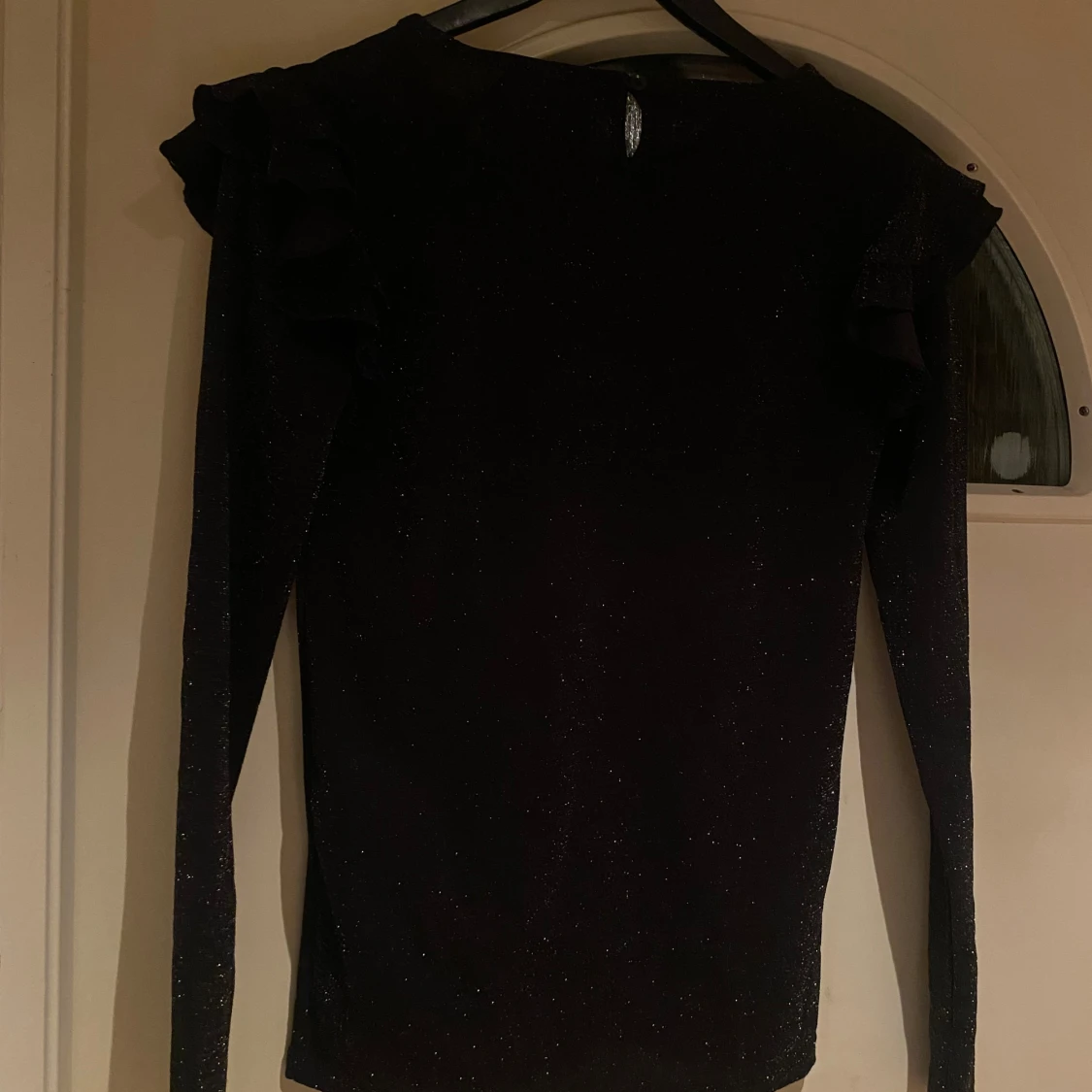 Svart glittrig topp med volang från Skill - 4