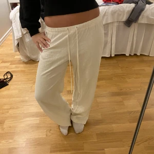 Vita linnebyxor från Pacific Republic - Säljer ett par vita linnebyxor från Pacific Republic. Byxorna har en avslappnad passform med breda ben, resår i midjan och snörning framtill. Perfekta för en chill och stilren look. Materialet är svalt och luftigt linne.