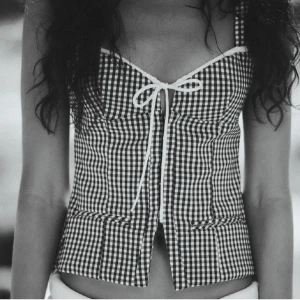 Svartvit rutig korsettopp från Zara - Säljer en svartvit rutig korsett från Zara med smala axelband och snygg snörning framtill. Super fin men kommer tyvärr inte till användning. En storlek M men liten i storleken så passar även S🩵🩵 TRYCK INTE PÅ KÖP INNAN DU SKRIVIT FÖRST