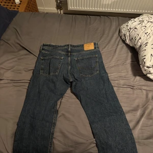 Jack & Jones Loose Chris jeans blå 34W/32L - Säljer ett par klassiska blå jeans från Jack & Jones, modell Loose Chris. Jeansen har en loose passform med raka ben och fem fickor. Tillverkade i slitstarkt denim med snygga kontrastsömmar. Perfekta för dig som gillar en avslappnad stil. Dom har bara använts några fåtal gånger. Priset är diskuterbart!