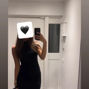 Svart tight ärmlös kortklänning - Säljer en svart, tight och ärmlös kortklänning med hög hals. Klänningen har en stilren och enkel design som sitter snyggt på kroppen och framhäver figuren. Perfekt för dig som gillar minimalistisk och trendig stil. #kortklänning #klänning