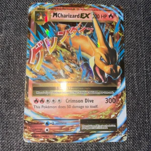 M Charizard EX Pokémon Card - Sällsynt M Charizard EX-kort. tydliga färger och inga synliga skador eller slitage. Perfekt för samlare eller spelare som vill stärka sin Pokémon-lek. Kortet är i mycket gott skick.