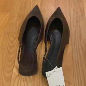 Bruna spetsiga skor  - Säljer ett par bruna skor  med spetsig tå. Skorna har en snygg krokodilpräglad yta i skinnimitation och platt sula. Perfekt för dig som gillar stilrena och trendiga detaljer. Passar dig som vill ha en elegant look med edge. Väldigt snyggt att ha med jeans eller kostymbyxor eller bara till en klänning. Passar alla årstider skulle jag säga. Endast testade🤍