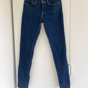 Levi's 711 Skinny jeans blå, stl 29 - Snygga mörkblå Levi's 711 Skinny jeans i klassisk femficksmodell. Jeansen har smal passform hela vägen ner, normal midja och är tillverkade i stretchigt denim för extra komfort. Perfekta för dig som gillar en stilren och modern look.