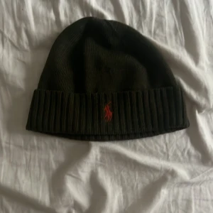 Oliv grön Ralph lauren mössa :Äkta - En oliv grön Ralph lauren mössa med rött märke, Säljer eftersom den inte passar min stil. Jag har aldrig använt den utan bara testat, inget kvitto eller förpackning kvar eftersom jag köpte mössan 1 år sedan och hittar dom inte. Om ni inte är nöjd med priset kan ni alltid kontakta mig får vi ta det därifrån😌