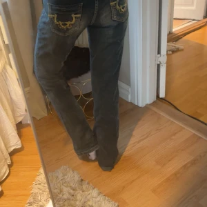 Missy’s jeans - Säljer ett par mörkblå jeans med snygga broderade detaljer i gult på bakfickorna. Nu pris 1000-1200