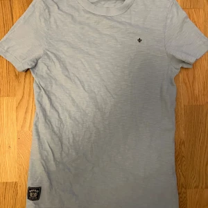 ljusblå Morris T-shirt - säljer nu denna ljusblåa Morris t-shirten som är i perfekt skick, nästan helt ny. Den är storlek xs men passar s. Skulle säga att den passar 170-180.