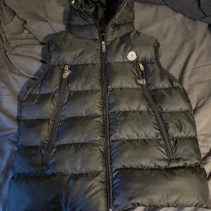 Svart Moncler Väst  - Svart Moncler Väst. Väldigt snygg och skön! Den är helt oanvänd! Det är storlek 4, runt L/XL