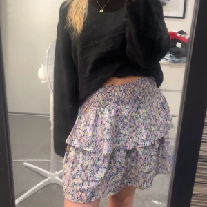 Volangkjol från Vero Moda - Supersöt kort kjol från Vero Moda med blommigt mönster i lila, gul och vit. Använd ca 2 gånger🤗🌟