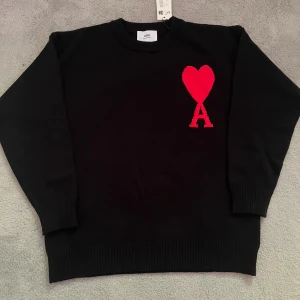 Ami paris tröja - Svart stickad tröja frän Ami Paris - Storlek S Tröjan är svart med den klassiska röda hjärtloggan pả bröstet. Skicket är helt ny med tag kvar! För fler frägor hör gärna av dig!❤️