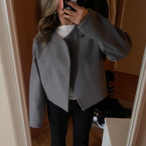 Grå kort jacka ginatricot - En oanvänd helt ny skick jacka från Ginatricot. Perfekt inför våren/hösten och det går att ha tjocktröja under. Jag är 156cm lång och jackan slutar precis vid mina höfter!💕