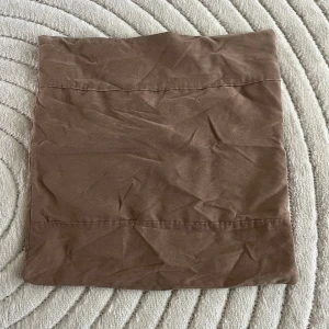 Brunt kuddfodral i sammet material - Ett brunt kuddfodral i sammet material i storlek 45 cm x 45 cm