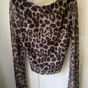 Leopardmönstrad topp  - Säljer en leopardmönstrad topp med öppen rygg. Aldrig använt den därför i väldigt bra skick.