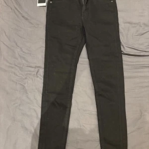 Svarta tapered jeans Jack & Jones - Svarta jeans från Jack & Jones i modellen Tapered/Pete. Byxorna har en smalare passform nedtill och klassisk femficksdesign. Tillverkade i ett stretchigt jeanstyg som ger en bekväm känsla och snygg siluett.