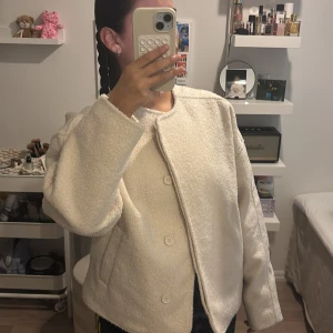 Vit teddyjacka från Nelly - Säljer en vit teddyjacka från Nelly i storlek S. Jackan är helt slutsåld. Jackan har rund hals, stora knappar framtill och en mjuk, fluffig yta. Perfekt för dig som gillar en clean och chill look. Jackan är långärmad och har en loose passform som ger skön vibe.