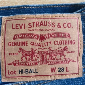 Levi's Hi-Ball jeans blå W28 - Snygga blå Levi's Hi-Ball jeans med klassisk röd Levi's-tag på bakfickan och original patch. Jeansen har rak passform och normal midja, tillverkade i slitstarkt denim. Perfekta för dig som gillar tidlös stil och vill ha ett par jeans som funkar till allt.