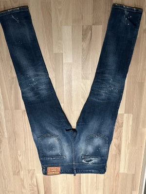  dsquared  jeans  - Säljer ett par mörkblå dsquared jean med coola slitningar och färgstänk för en edgy look. Jeansen är i i modellen Cool guy.vid  frågor eller funderingar är det bara att skriva.//Samuel